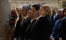 The Roy family dressed all in black at the front row of a funeral in a large church.