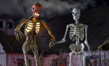home depot's inferno pumpkin skeleton and original 12-foot skeleton against a spooky backdrop