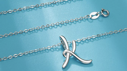 sterling silver necklace with K initial on blue background