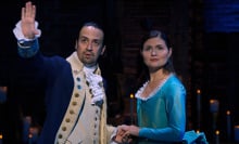 Two people in period garb stand on stage in a production of "Hamilton."