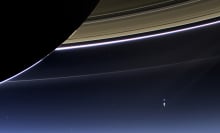 An arrow pointing to the Earth (a blue dot) with Saturn's rings in the foreground.