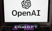 OpenAI logo on a laptop with the ChatGPT logo on a smartphone resting on the keyboard