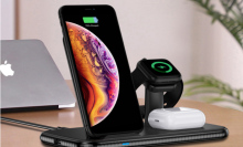 wireless charging hub charging up an iphone, a smartwatch, and airpods.
