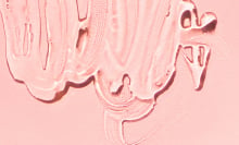 A close up of lube on a light pink background. 