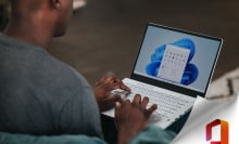 man using laptop with microsoft logo in corner