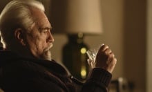 An old man drinking a glass of whiskey while seated.