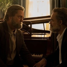 Bill and Frank from "The Last of Us" sit together at a piano, holding hands.