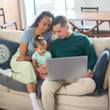 A family gathers around a computer.