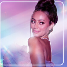 A photo of Emira D'Spain glammed up and looking over her shoulder, photoshopped on a blue, purple, and pink background. 