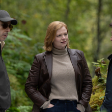 In "Succession" two men and a woman in smart clothing stand conversing in a forest. 