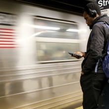 Subway rider checks his phone