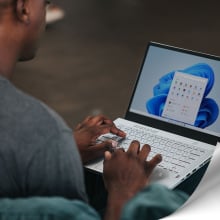 man using laptop with microsoft logo in corner