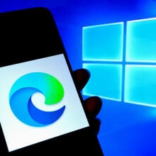 Microsoft Edge logo on phone screen next to Windows logo