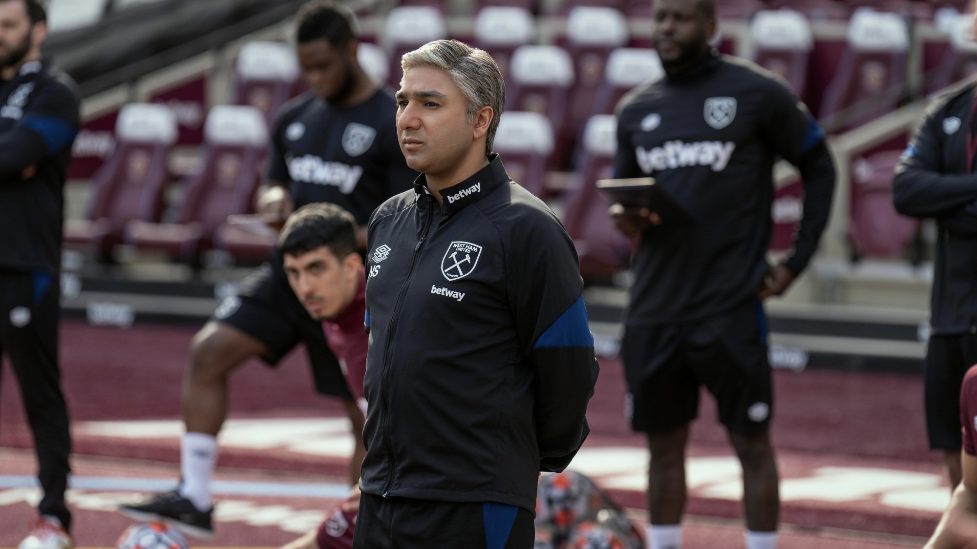 Nate from "Ted Lasso" coaches West Ham practice from the sidelines of their stadium.