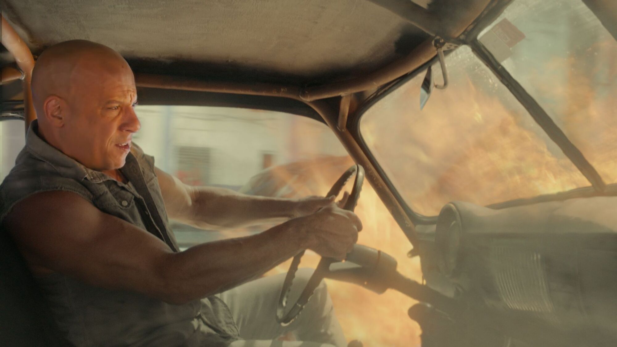 Vin Diesel drives a car on fire in "The Fate of the Furious"