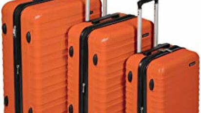 Orange luggage set from AmazonBasics on a white background.