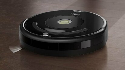 iRobot Roomba 675 cleaning dark wooden floors.