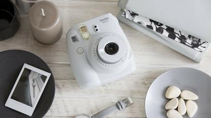 a white Instax camera on a table