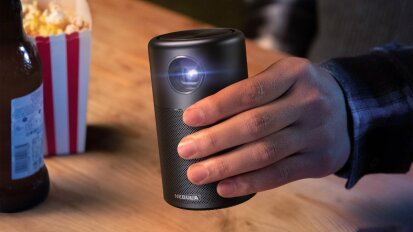 Person holding a portable projector from Anker.