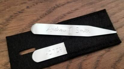 Personalized collar stays from Engraved Memories on a wooden table.