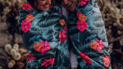 Two women bundled in Rumpl blankets outside