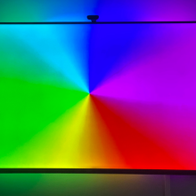 TV with rainbow wheel onscreen and matching colored lights behind the TV