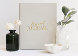 a travel journal surrounded by nice things