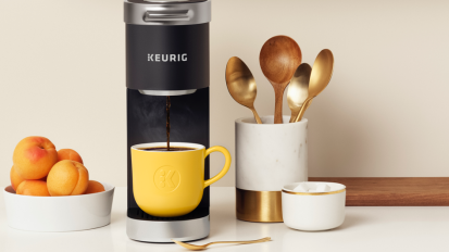 black keurig with yellow coffee cup on a counter