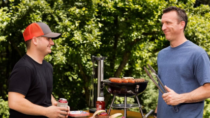 Two people with a portable grill from Cuisinart.