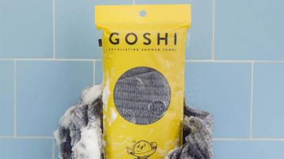 Goshi exfoliating towel on a blue tile.