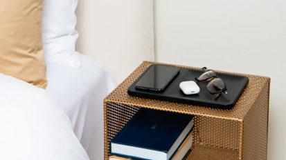 The Courant Catch:3 wireless charging tray on a bedside table.