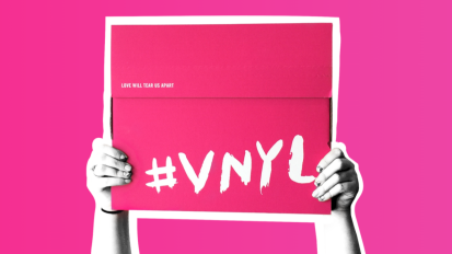 Someone holding a sign that says #VNYL on a pink background.