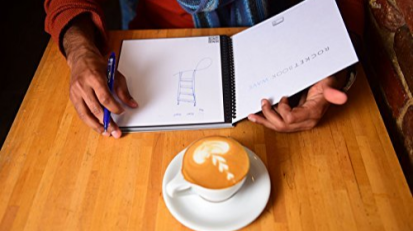 Person holding a Rocketbook Wave in a coffee shop.