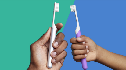 Two people holding quip toothbrushes on a colorful background.