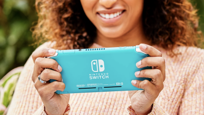 a person holding a teal nintendo switch lite