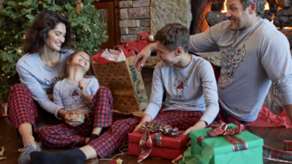 family wearing pajamas in front of Christmas tree