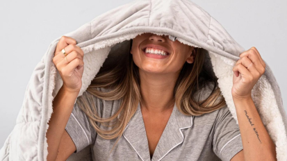 Person with sherpa-lined weighted blanket over their head