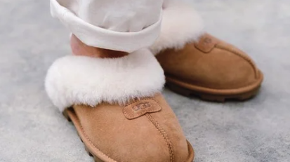 Person's feet wearing UGG slippers with fur
