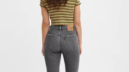 Person wearing black Levi's jeans and striped shirt