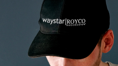 a close-up of a man wearing a black hat from the succession merch line