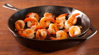 a close-up of a 12-inch lodge cast iron skillet filled with shrimp