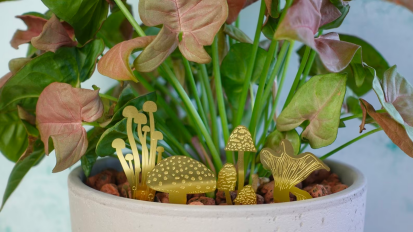 a close-up of brass mushrooms decorations in a potted plant